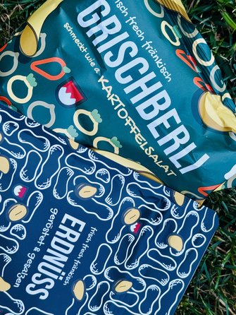 Auf dem Bild sind Tüten mit Knabbereien zu sehen. Es sind fränkische Chips und fränkische Erdnüsse.