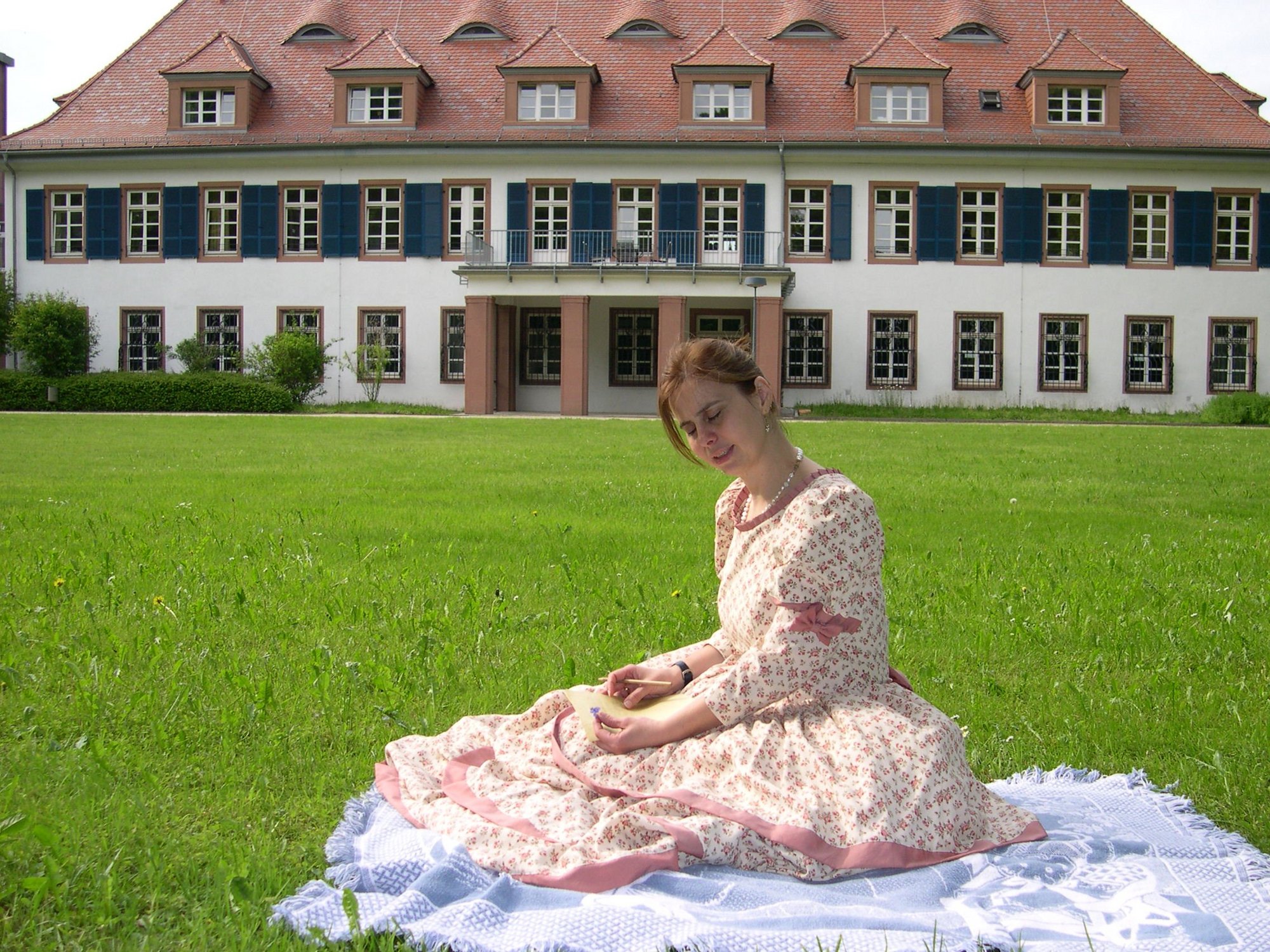 Frau im Biedermeierkleid vor Schloss Wasserlos