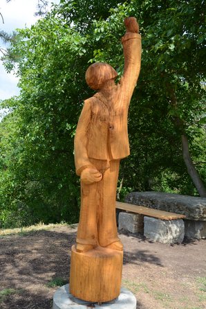 Zu sehen ist die Skulptur "Winzer 21" von Daniel Grimme am terroir f-Aussichtspunkt in Sommerhausen. Es ist eine 2 Meter große Holzfigur einers Winzers mit Rebschere und hoch gerecktem Glas. 