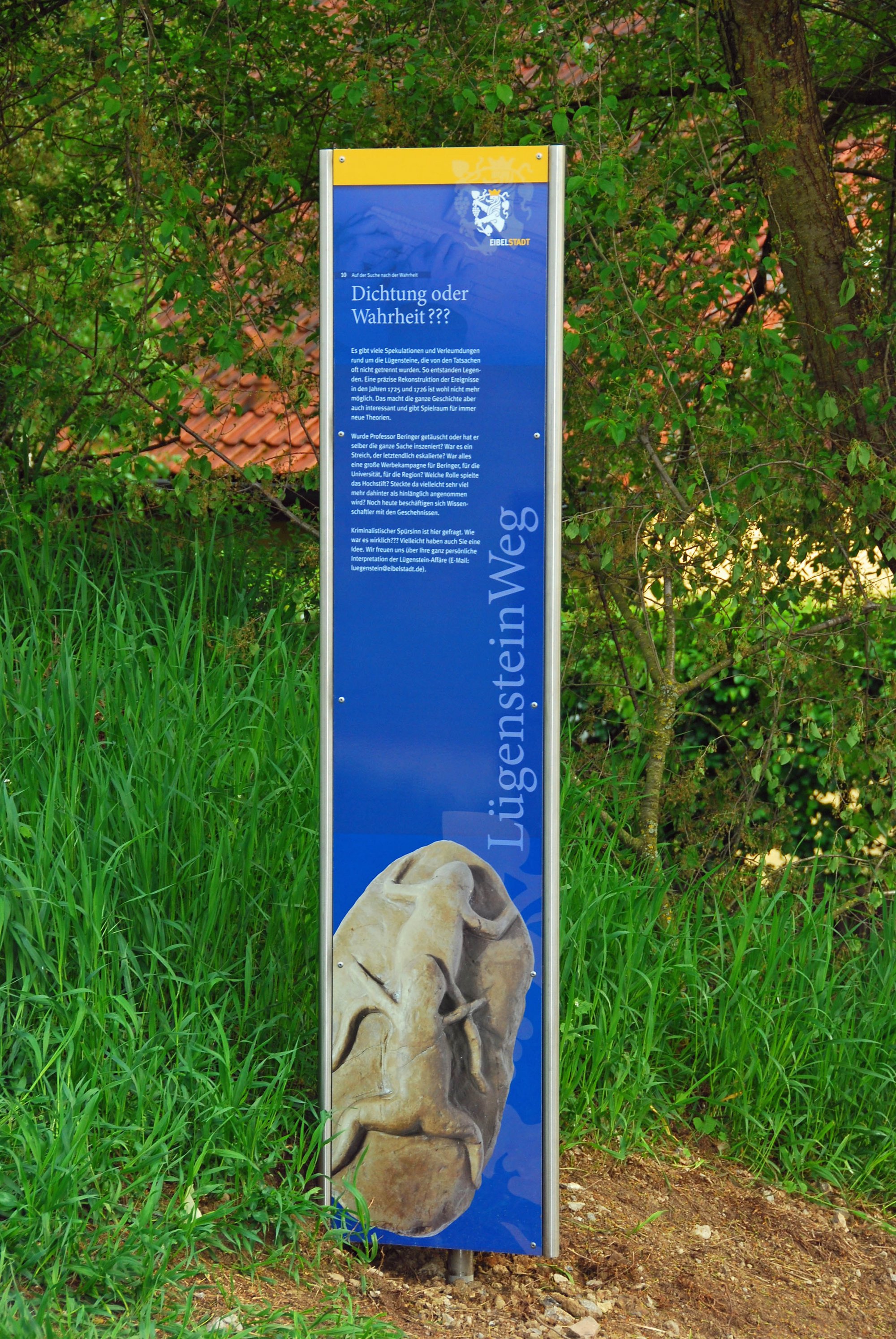 Es ist eine blaue Stele vom LügensteinWeg in den Eibelstadter Weinbergen zu sehen. 