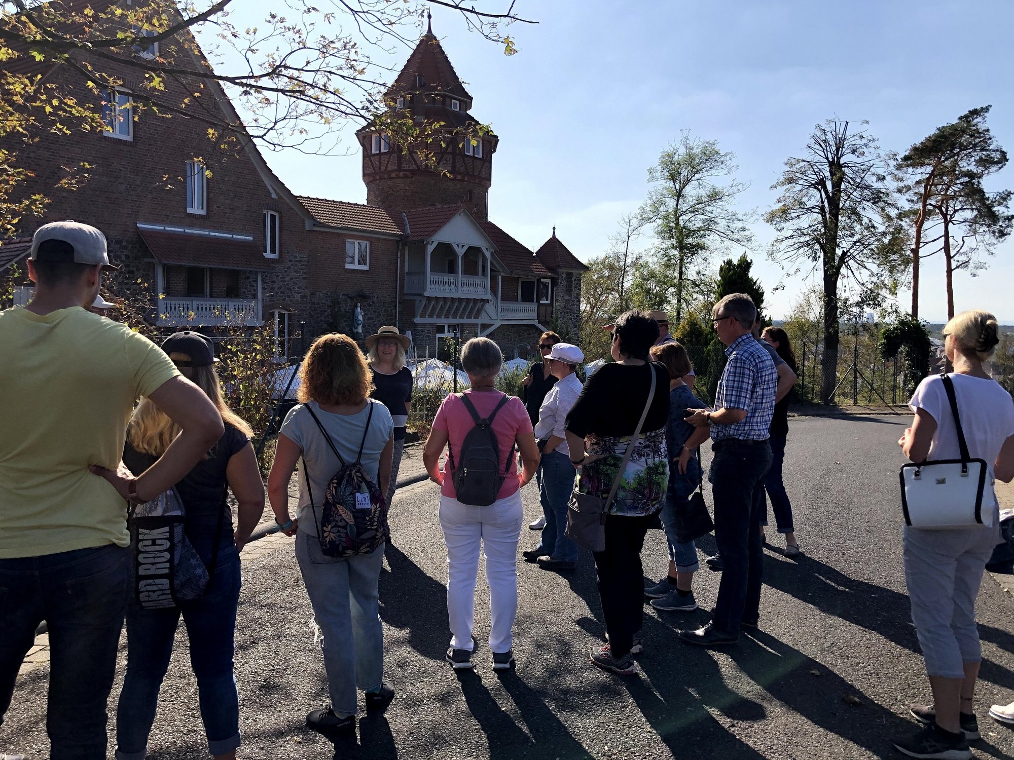 Personengruppe vor einer alten Villa